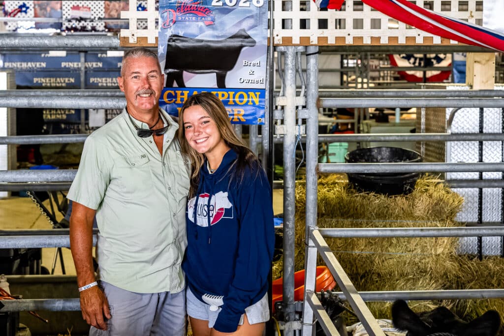 Keith and Gillian Shane of Bank Run Farm pose for a picture next to their Champion Heifer banner that Gillian won in the Bred and Owned Class.
