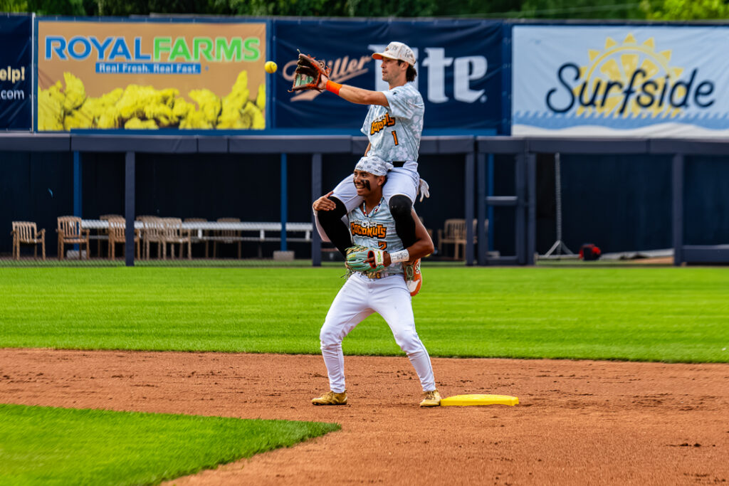 Coconuts Peyton Chatagnier (No. 1) fields the throw down to second on Sal Jacobo's (No. 2) shoulders during warmups.