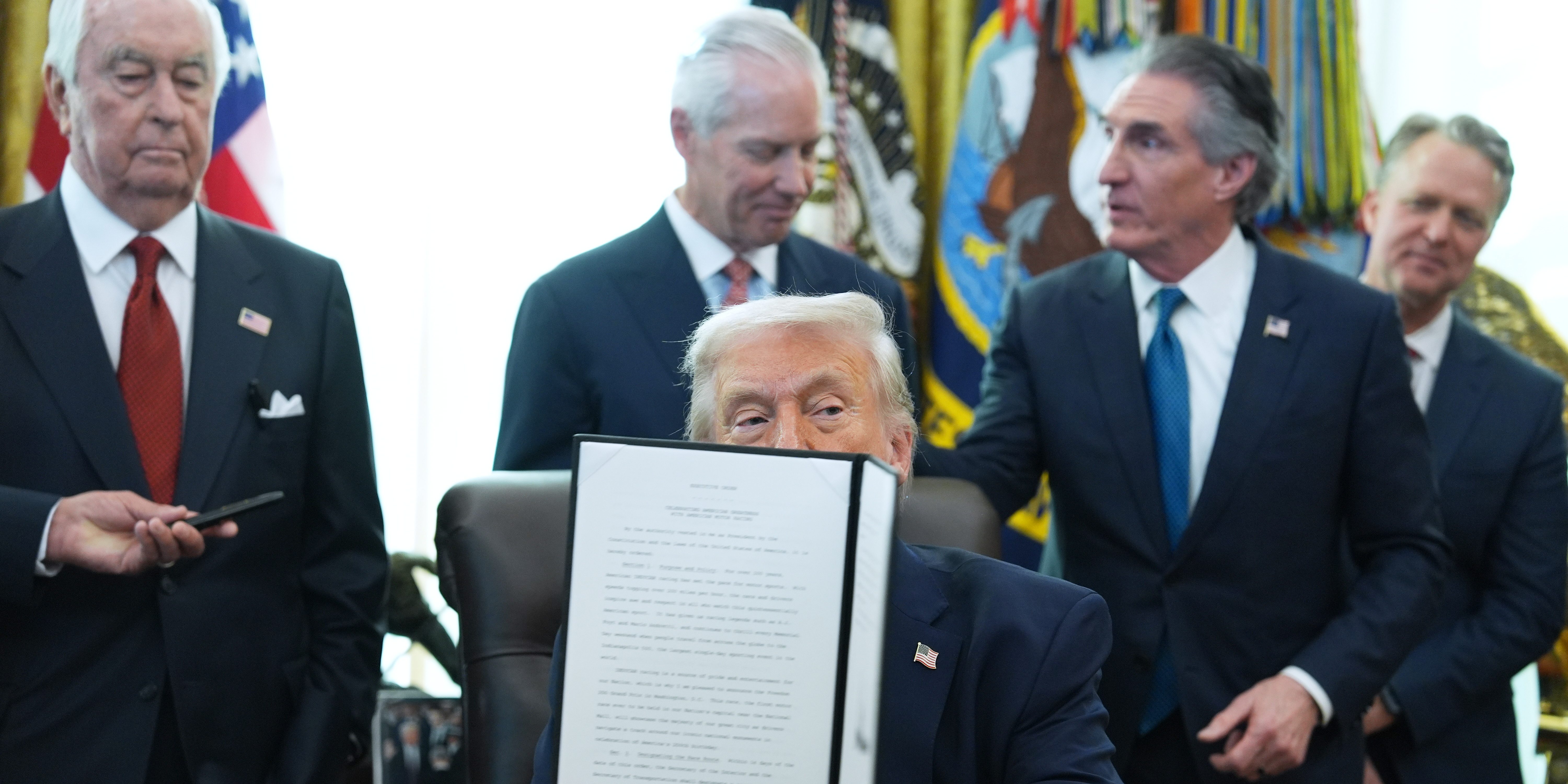 President Donald Trump holds an executive order he signed in the Oval Office of the White House, Friday, Jan. 30, 2026, in Washington.