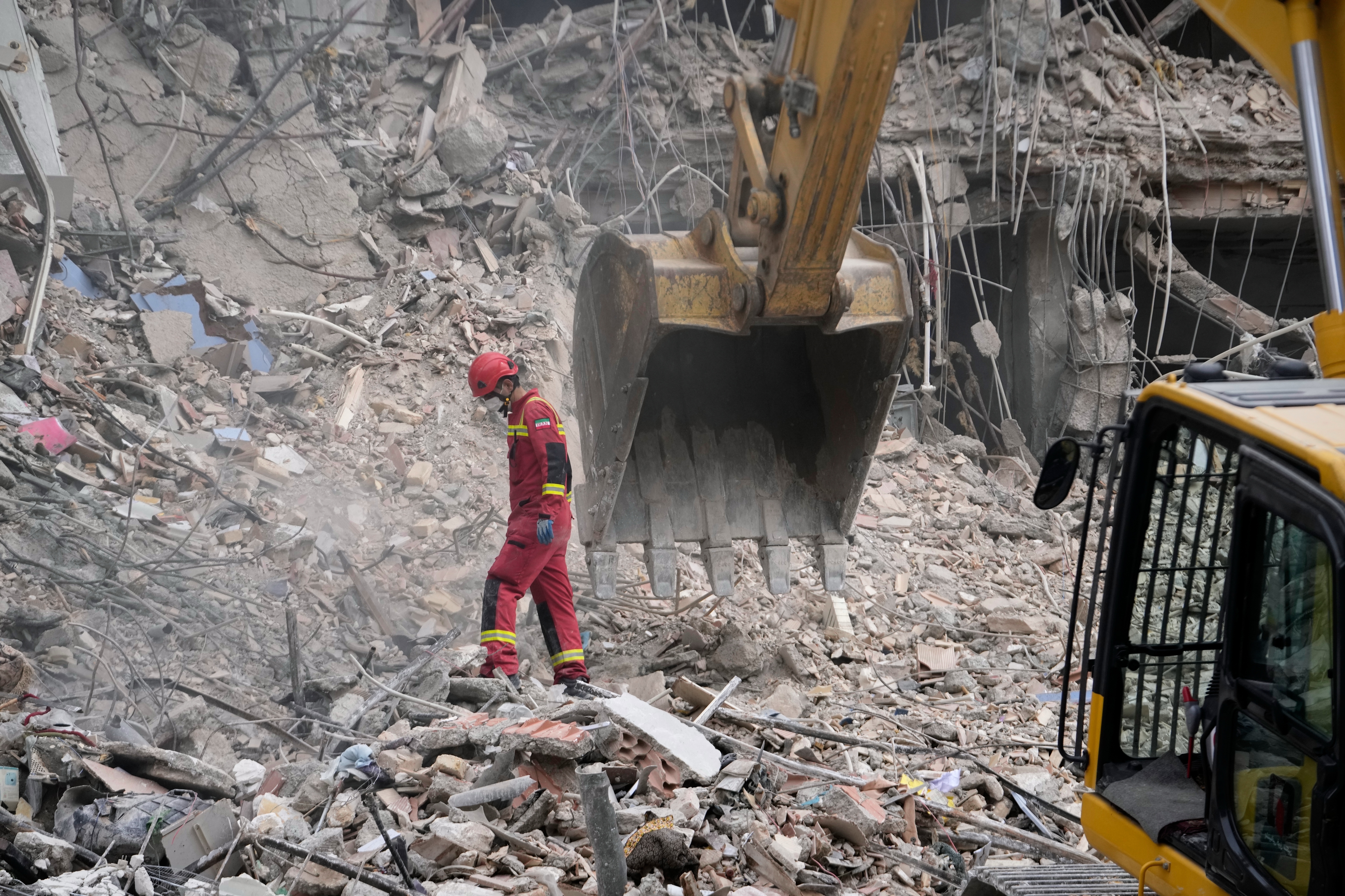 Iranian Red Crescent emergency workers use a bulldozer to clear rubble from a residential building that was hit in an earlier U.S.-Israeli strike in Tehran, Iran, Monday, March 23, 2026. (AP Photo/Vahid Salemi)