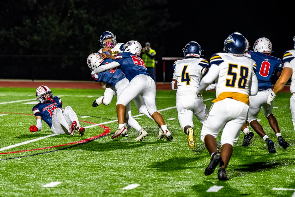 Patriot defenders Alexander Burrows (No. 9) and Jayden Roberts (No. 58) combine for a sack. Photo Credit: Dave Reeder