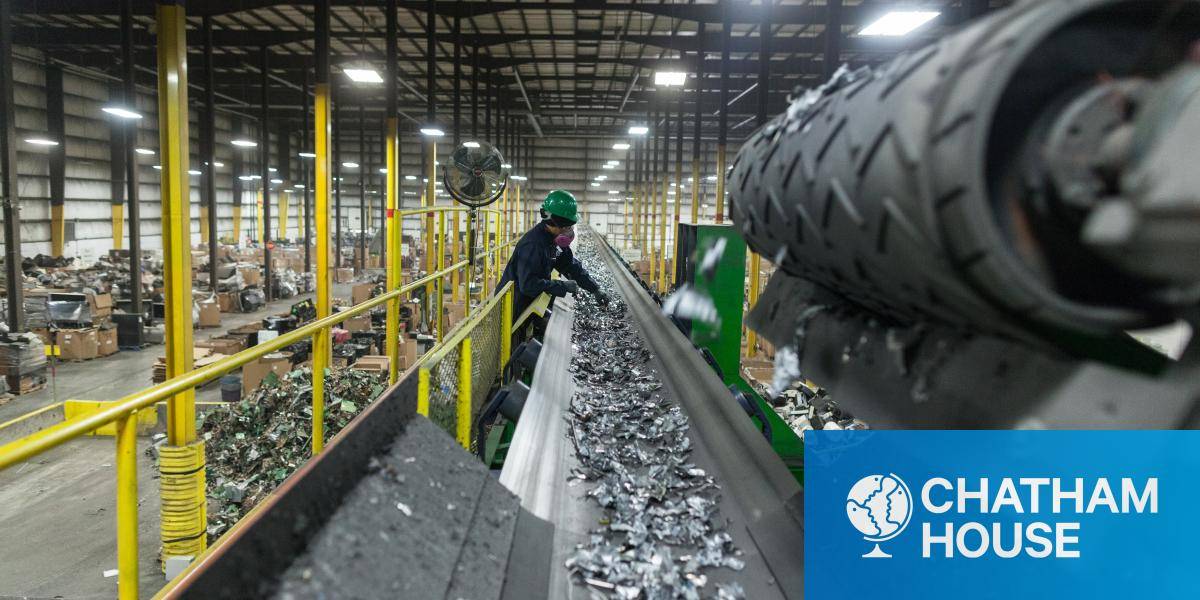 A worker sorts metal recyclable waste at a plant