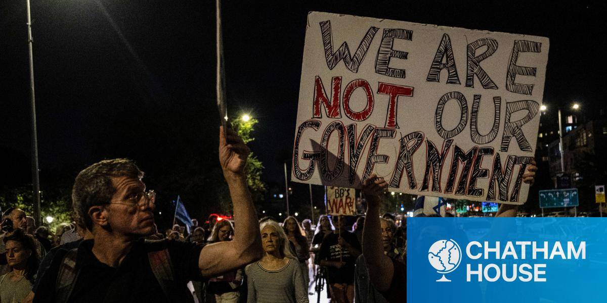 Demonstrators&nbsp;in West Jerusalem hold a placard reading 'we are not our government'