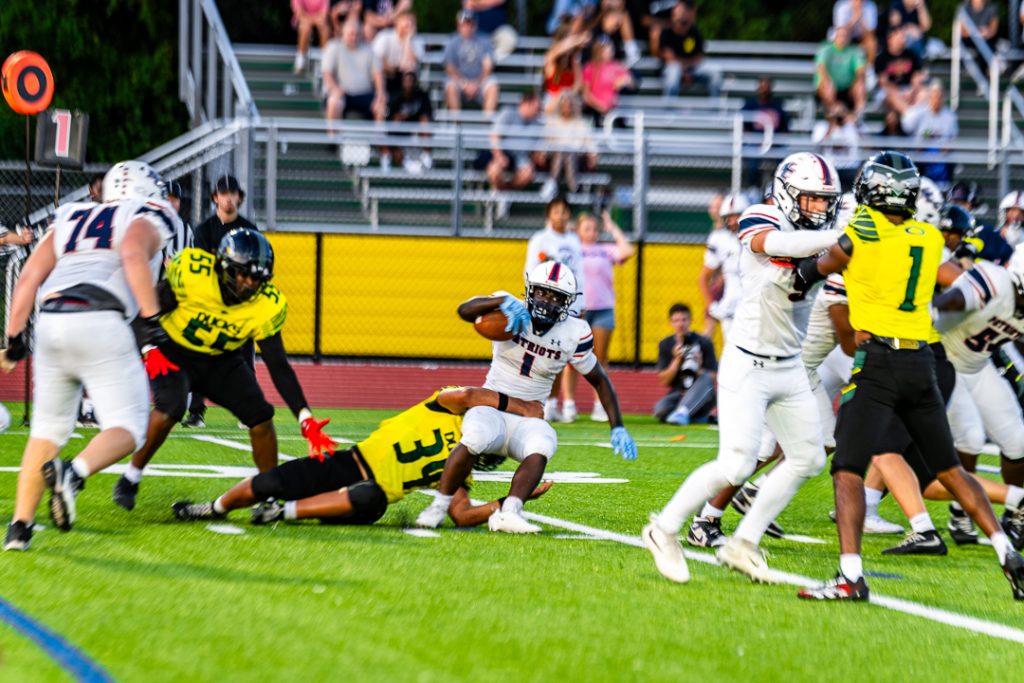 Patriot senior Austin Gbadegbe is brought down by a Duck defender after gaining yardage on the run.