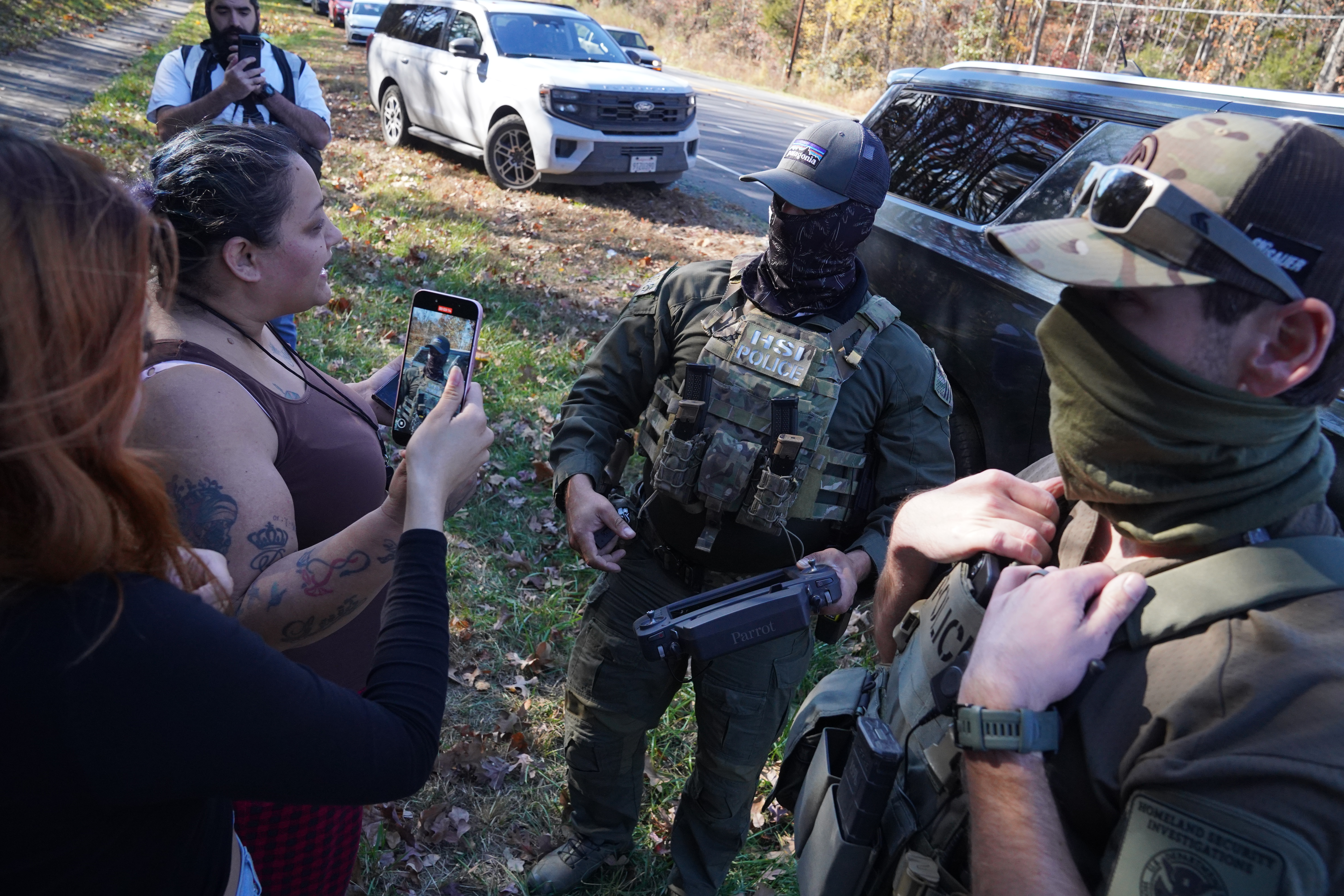 CHARLOTTE, NORTH CAROLINA - NOVEMBER 16: Department of Homeland Security Investigations officers search for two individuals who fled the scene after being stopped while selling flowers on the side of the road on November 16, 2025 in Charlotte, North Carolina. This comes on the second day of "Operation Charlotte's Web," an ongoing immigration enforcement surge across the Charlotte region. (Photo by Ryan Murphy/Getty Images)