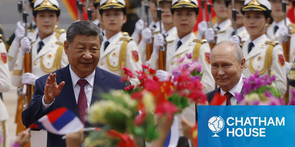 President Vladimir Putin and President Xi Jinping at a welcoming ceremony with soldiers in white uniforms parading behind them