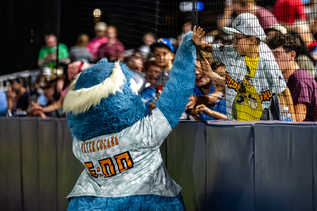 One of the Loco Beach Coconuts' mascots, Peter Colada, interacts with a fan during the first Banana Ball game in Wilmington, Delaware. Photo Credit: Dave Reeder.