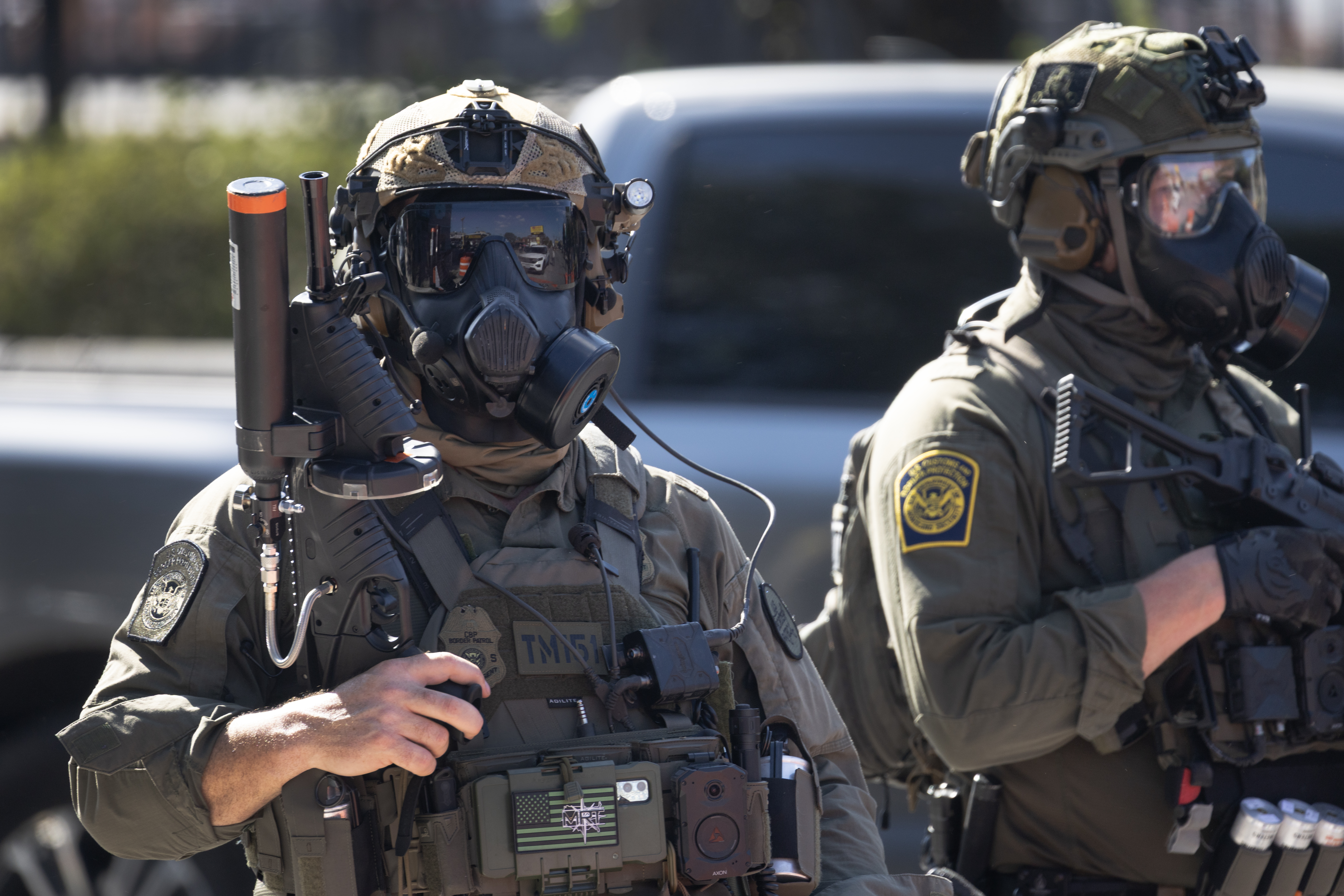 CHICAGO, ILLINOIS - OCTOBER 04: Federal law enforcement agents stand guard as they are confronted by community members and activists for reportedly shooting a woman in the Brighton Park neighborhood on October 04, 2025 in Broadview, Illinois. Residents of the city have become increasingly concerned as Operation Midway Blitz continues in the Chicago area, an operation designed to apprehend and deport undocumented immigrants living in the area.  (Photo by Scott Olson/Getty Images)