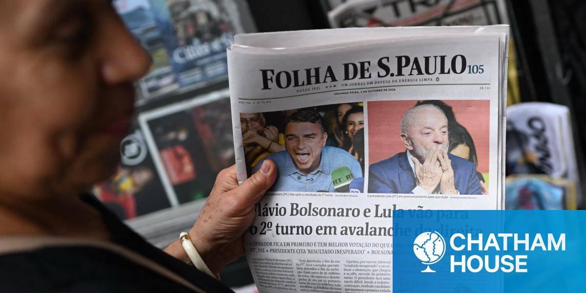 A woman holds a copy of the Folha de Sao Paulo newspaper displaying coverage of Brazil's presidential election results.