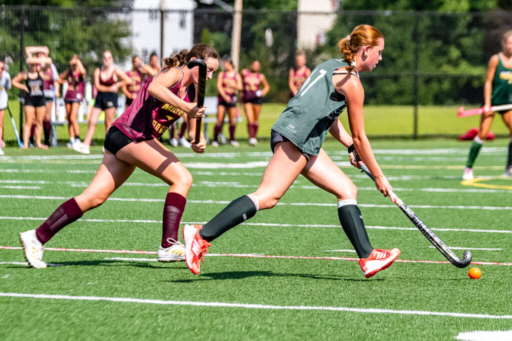 A Spartan player dribbles the ball down field while the Milford defense pursues. 