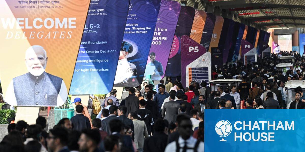 Visitors walk past a banner featuring India's Prime Minister Narendra Modi, as they arrive at the AI Impact Summit in New Delhi