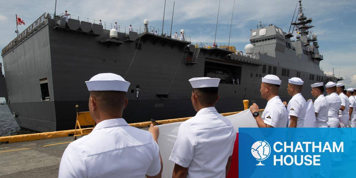 Philippine Navy sailors hold a Japanese flag in front of a Hyuga-class helicopter destroyer of the Japan Maritime Self-Defense Force, in Manila on 21 June 2025. (