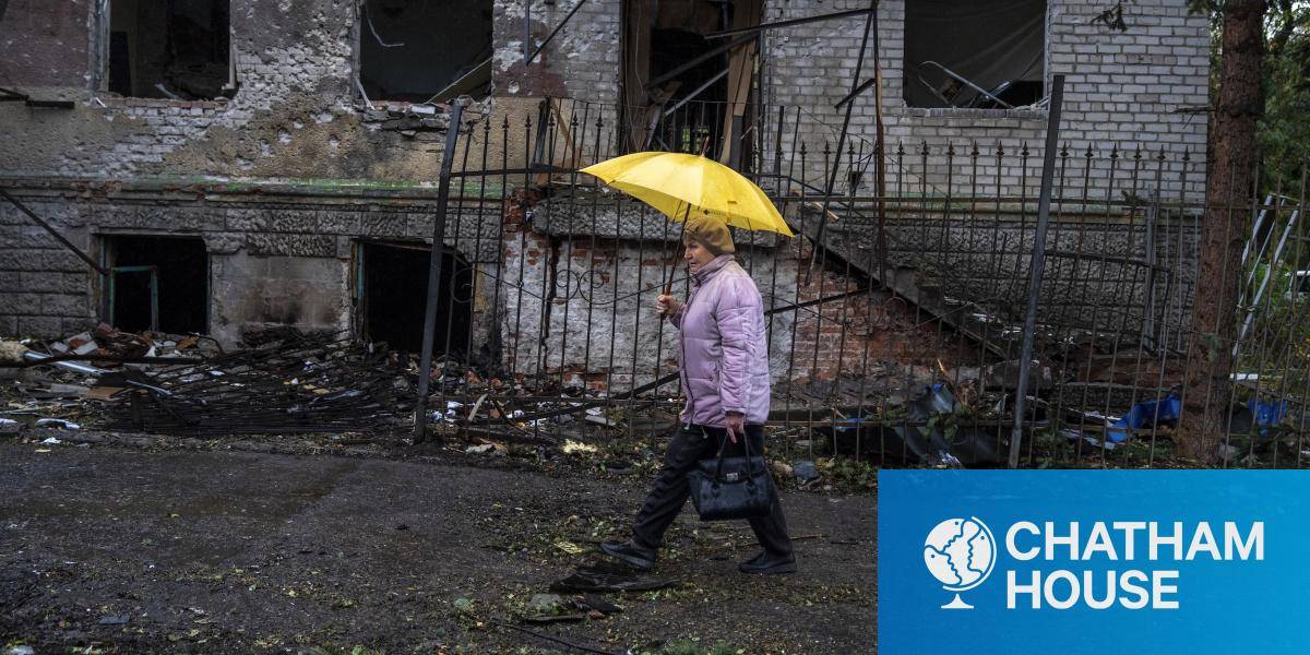 A woman walks with an umbrella by a damaged house in the city of Kramatorsk, Ukraine on 13 October 2025. (Photo by Jose Colon/Anadolu via Getty Images)