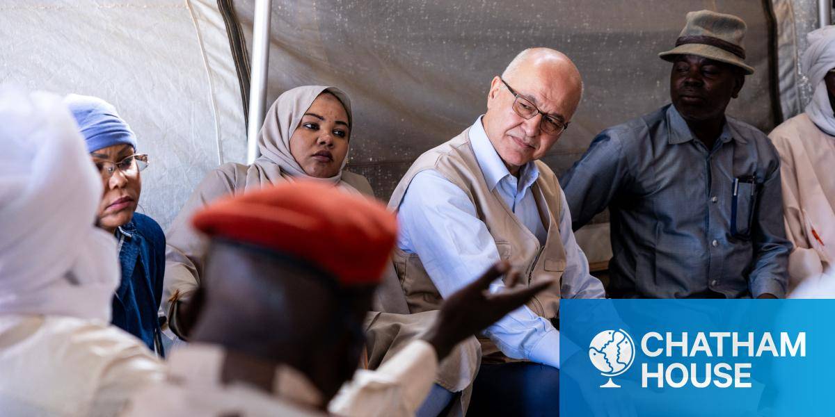 Barham Salih sits in tent speaking to refugees